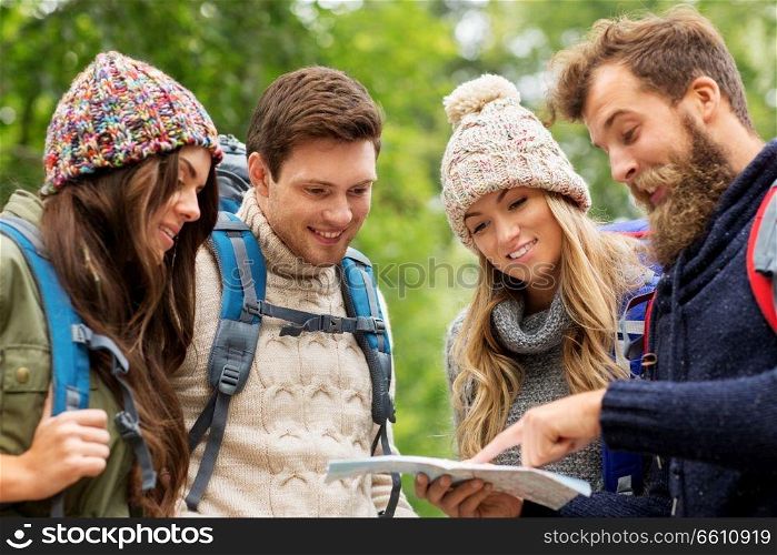 travel, tourism, hiking and people concept - group of happy friends or travelers with backpacks and map. friends or travelers hiking with backpacks and map