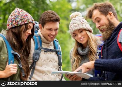 travel, tourism, hiking and people concept - group of happy friends or travelers with backpacks and map. friends or travelers hiking with backpacks and map
