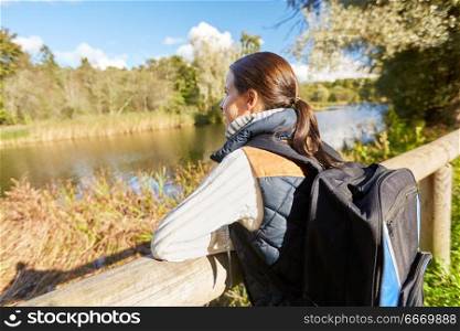 travel, tourism, hiking and people concept - happy woman with backpack outdoors. happy woman with backpack hiking. happy woman with backpack hiking