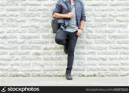 travel, tourism, lifestyle and people concept - close up of man with backpack standing at city street wall