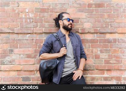 travel, tourism, lifestyle and people concept - happy smiling man with backpack standing at city street wall
