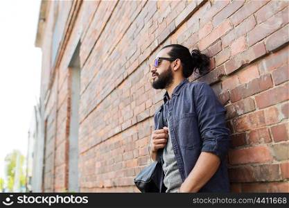 travel, tourism, lifestyle and people concept - man with backpack standing at city street wall
