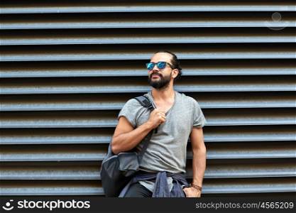 travel, tourism, lifestyle and people concept - man with backpack standing at city street wall