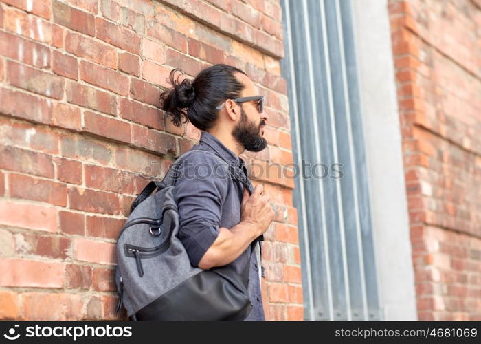 travel, tourism, lifestyle and people concept - man with backpack standing at city street wall