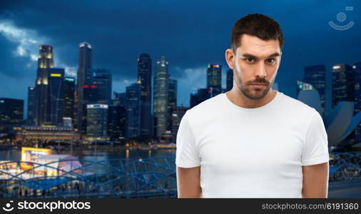 travel, tourism, people concept - young man portrait over night singapore city background