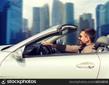 travel, tourism, road trip, transport and people concept - happy man driving cabriolet car outdoors