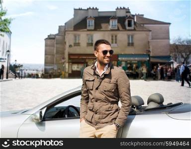 travel, tourism, road trip, transport and people concept - happy man near cabriolet car over city background