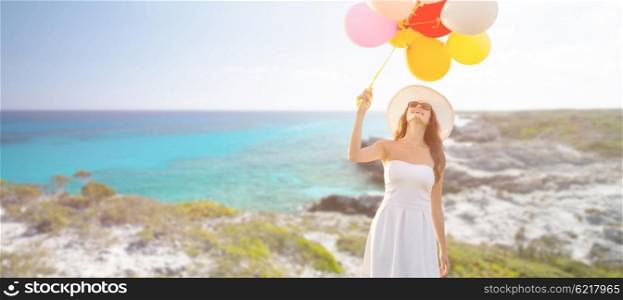 travel, tourism, summer, holidays and people concept - smiling young woman wearing sunglasses with balloons over exotic tropical beach and sea background
