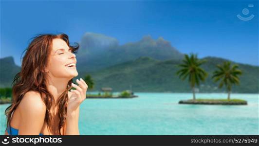 travel, tourism, summer holidays and vacation concept - happy young woman enjoying sun at touristic resort over bora bora island beach background. happy woman enjoying sun on bora bora beach