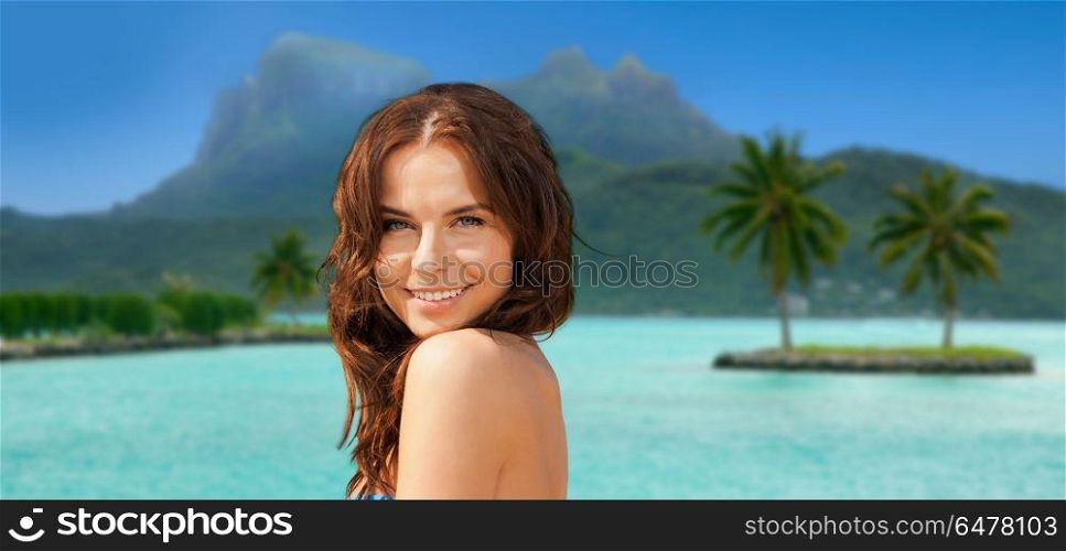 travel, tourism, summer holidays and vacation concept - happy young woman posing in bikini swimsuit at touristic resort over bora bora island beach background. happy woman in bikini swimsuit on bora bora beach. happy woman in bikini swimsuit on bora bora beach