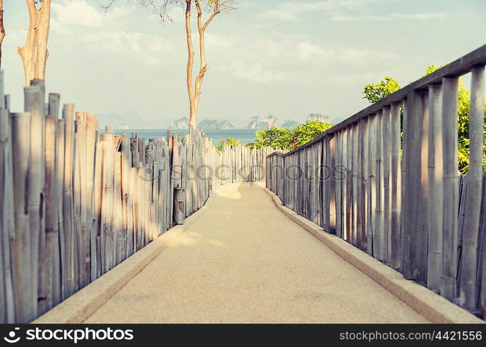 travel, tourism, summer holidays, vacation and leisure concept - road with fence at seaside