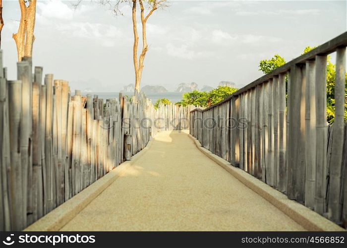 travel, tourism, summer holidays, vacation and leisure concept - road with fence at seaside
