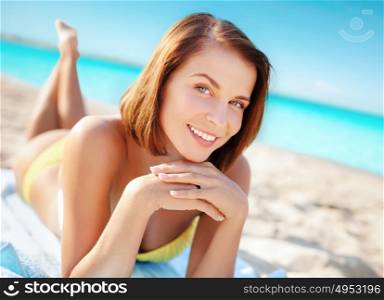 travel, tourism, summer holidays, vacation and people concept - happy beautiful woman in bikini sunbathing over exotic tropical beach background. woman in bikini sunbathing on beach