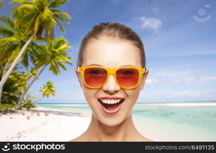 travel, tourism, summer holidays, vacation and people concept - smiling young woman or teenage girl in sunglasses over exotic tropical beach background. happy woman or teenage girl in sunglasses on beach. happy woman or teenage girl in sunglasses on beach