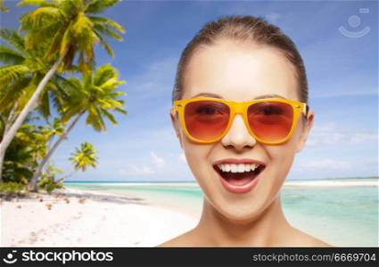 travel, tourism, summer holidays, vacation and people concept - smiling young woman or teenage girl in sunglasses over exotic tropical beach background. happy woman or teenage girl in sunglasses on beach. happy woman or teenage girl in sunglasses on beach
