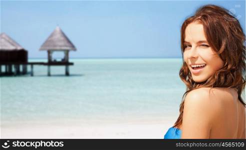 travel, tourism, summer vacation and people concept - happy beautiful woman over tropical beach with bungalow background
