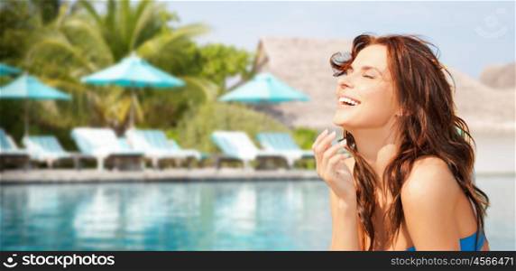 travel, tourism, summer vacation and people concept - happy beautiful woman over beach or resort hotel swimming pool background