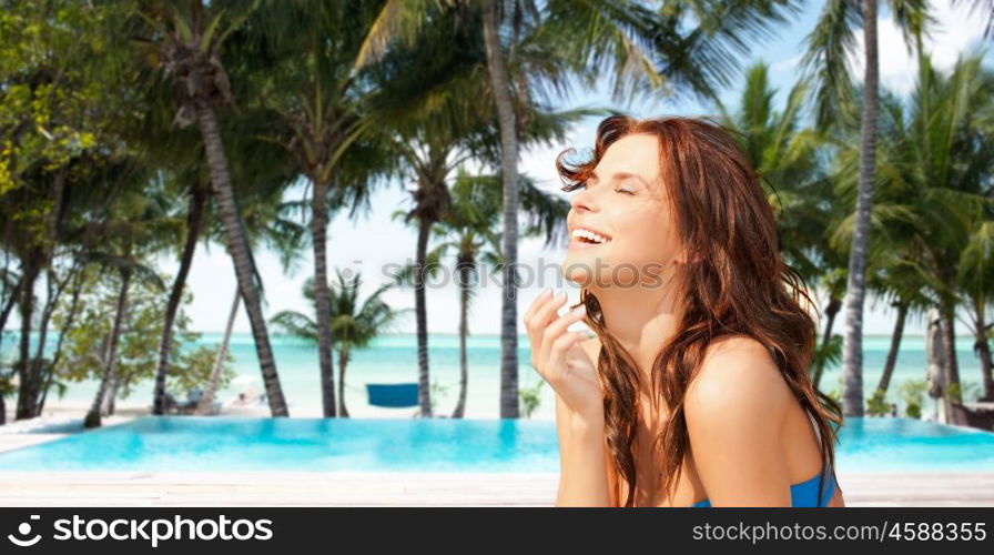 travel, tourism, summer vacation and people concept - happy beautiful woman over beach or resort hotel swimming pool background