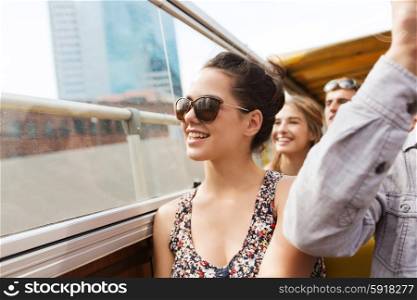 travel, tourism, summer vacation, sightseeing and people concept - happy teenage girl in sunglasses with group of friends traveling by tour bus