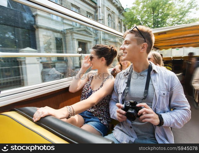 travel, tourism, summer vacation, sightseeing and people concept - smiling teenage couple with camera traveling by tour bus