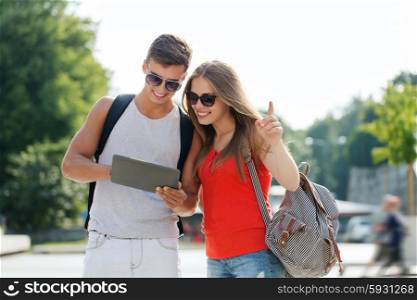 travel, tourism, summer vacation, technology and friendship concept - smiling couple with tablet pc and backpack in city