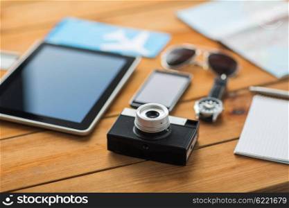 travel, tourism, technology and objects concept - close up of retro film camera, gadgets and personal stuff