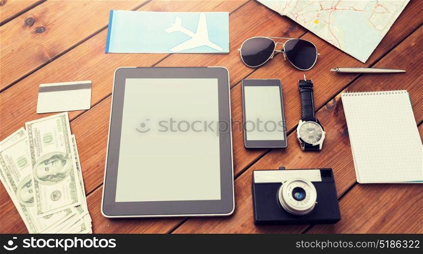 travel, tourism, technology and objects concept - close up of smartphone with tablet pc computer, airplane ticket and personal stuff. close up of smartphone and travel stuff