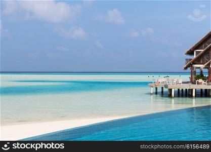 travel, tourism, vacation and summer holidays concept - access to patio or terrace with canopy on maldives beach sea shore