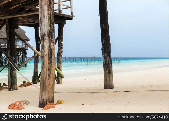 travel, tourism, vacation and summer holidays concept - bungalows or stilt houses on tropical resort beach. bungalows or stilt houses on tropical resort beach
