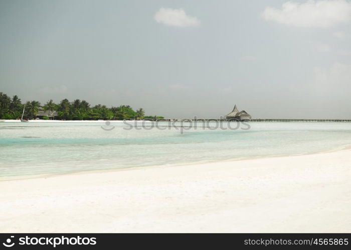 travel, tourism, vacation and summer holidays concept - maldives island beach with palm tree and villa