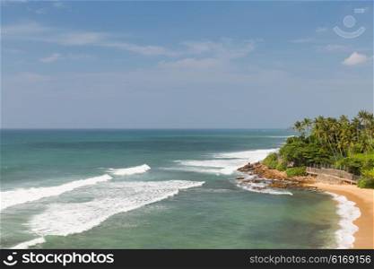 travel, tourism, vacation, seascape and summer holidays concept - sea or ocean waves and blue sky on Sri Lanka beach
