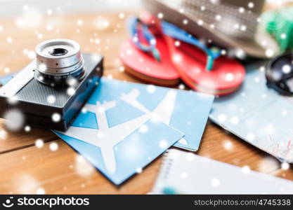 travel, tourism, winter holidays and objects concept - close up of camera, airplane tickets and personal accessories