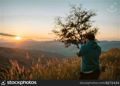 Travel tourist alone Hiking adventure. Young man standing on top of cliff in summer mountains with sunset enjoy view nature cliff mountain.