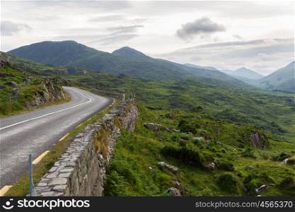 travel, trip and countryside concept - view to asphalt road and rocky hills at connemara in ireland