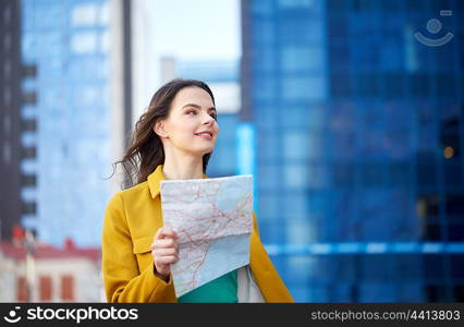 travel, trip, tourism, people and vacation concept - happy young woman with map walking along city street