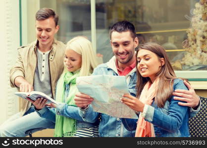 travel, vacation and friendship concept - group of smiling friends with city guide and map exploring town