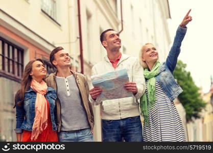 travel, vacation and friendship concept - group of smiling friends with city map exploring city