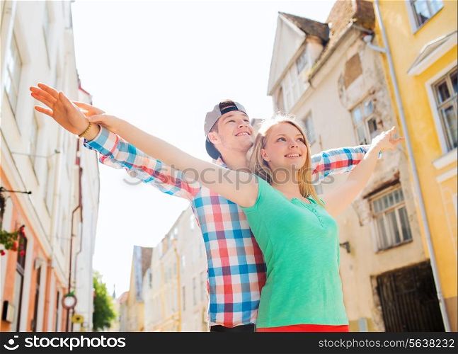 travel, vacation and friendship concept - smiling couple in city