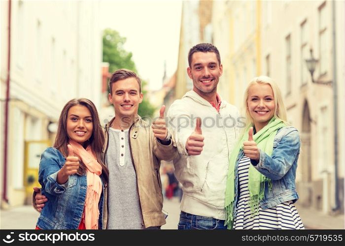 travel, vacation and gesture concept - group of smiling friends showing thumbs up