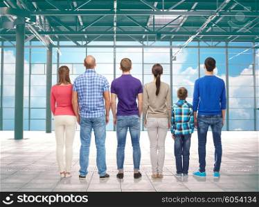 travel, vacation and people concept - group of happy people or big family from back over airport terminal window and sky background