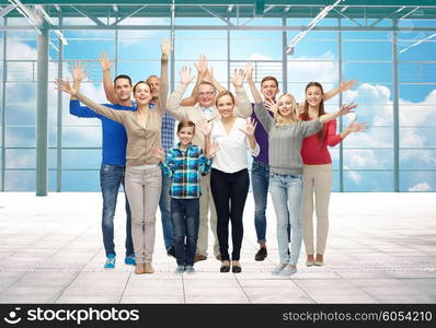 travel, vacation and people concept - group of happy people or big family waving hands over airport terminal window and sky background