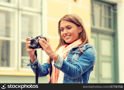 travel, vacation and technology concept - smiling girl with digital photocamera in the city