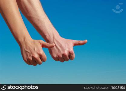 Travel vacation hitchhiking and happiness concept. Male hands thumbing and hitch hiking outdoor, thumb up gesture against blue sky. Male hands thumbing and hitch hiking outdoor