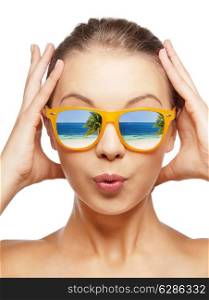 travel, vacation, summer holidays and happy people concept - portrait of amazed teenage girl in sunglasses with beach reflection
