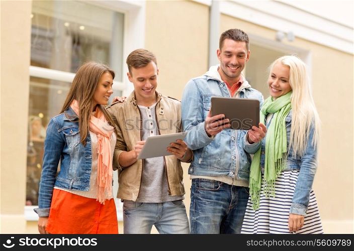 travel, vacation, technology and friendship concept - group of smiling friends with tablet pc computers in the city