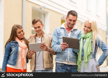 travel, vacation, technology and friendship concept - group of smiling friends with tablet pc computers in the city