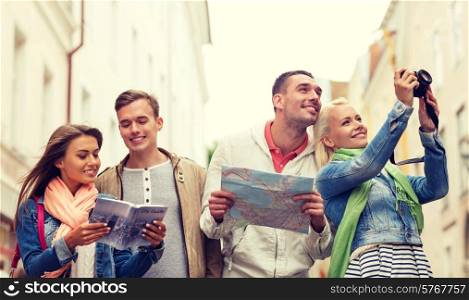 travel, vacation, technology and friendship concept - group of smiling friends with city guide, photocamera and map exploring city