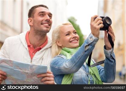 travel, vacation, technology and friendship concept - smiling couple with map and photocamera exploring city