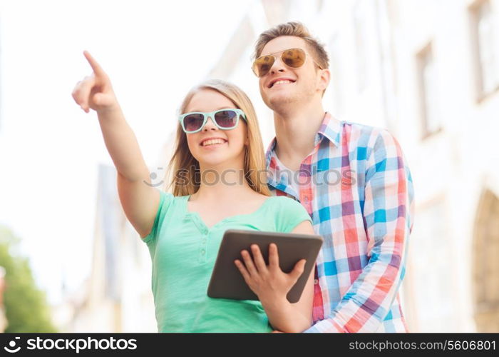 travel, vacation, technology and friendship concept - smiling couple with tablet pc computer in city