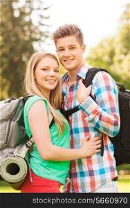 travel, vacation, tourism and friendship concept - smiling couple with backpacks in nature